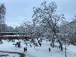 Pausenzeit. Die Schulkinder spielen in der Pause auf dem verschneiten Schulhof mit dem Schnee. 